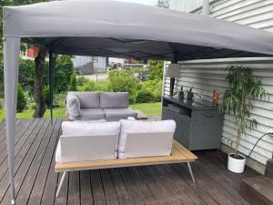 a patio with a couch and an umbrella on a deck at Silja in Pärnu