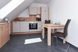 cocina con mesa de madera, mesa y silla en Haus Veermaster, en Neuharlingersiel