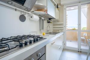 uma cozinha com balcões brancos e um forno com placa de fogão em Kalbia Apartment or Rooms Renovated, functional, intimate and more em Cagliari