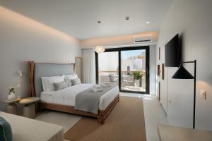 a bedroom with a bed and a balcony at Anapollo Boutique Hotel Adults Only in Naxos Chora