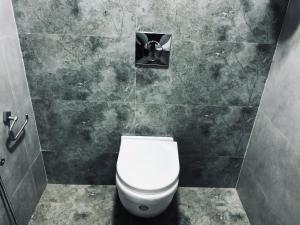 bagno con servizi igienici bianchi in una cabina di Garuda Suites a Varkala