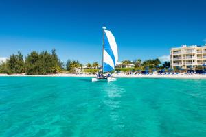 um veleiro na água perto de uma praia em Windsong on the Reef em Grace Bay