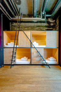 ein Zimmer mit 4 Etagenbetten mit Schuhen drauf in der Unterkunft Silo Design & Boutique Hostel Basel in Basel