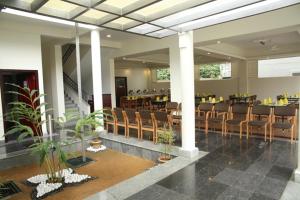 un hall avec un restaurant avec des chaises et des tables dans l'établissement Peppervine Hotel, à Thekkady