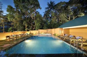 - une piscine avec des chaises et une table dans l'établissement Peppervine Hotel, à Thekkady