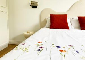 een bed met een witte sprei met bloemen erop bij Le petit Versailles - T2 au centre-ville in Grenoble