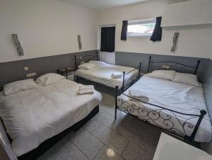 2 camas individuales en una habitación con ventana en Hotel-Chao NL 24 hours open, en Utrecht