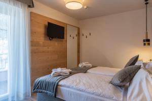 een slaapkamer met 2 bedden en een flatscreen-tv bij Hotel Meida in Pozza di Fassa