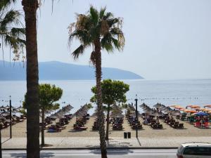 plaża z leżakami i parasolami oraz ocean w obiekcie Charm Hotel we Wlorze