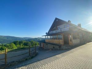 uma casa numa colina com o sol ao fundo em Michałówka na Kubalowej Łące em Szczyrk