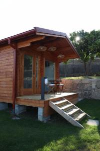 una cabina in legno con terrazza e tavolo di Refugio D Alecrim a Paredes