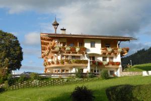 un edificio en una colina con flores. en Hotel Landhaus Marchfeld, en Oberau