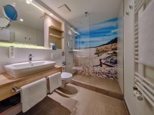 La salle de bains est pourvue d'un lavabo et de toilettes. dans l'établissement Dorint Seehotel Binz-Therme, à Binz