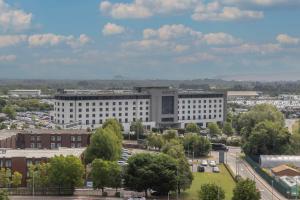 um grande edifício branco com carros estacionados num parque de estacionamento em Radisson Blu Hotel Dublin Airport em Cloghran