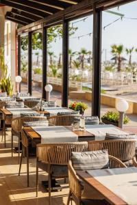 una fila di tavoli e sedie in un ristorante di Hotel Hawaii a Mamaia