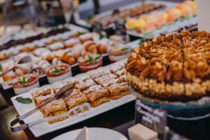 een buffet met verschillende soorten desserts en taarten bij Hotel Merkur - Czech Leading Hotels in Praag