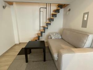 a living room with a couch and a staircase at Stadtapartment WOHNEN48.AT in Klagenfurt