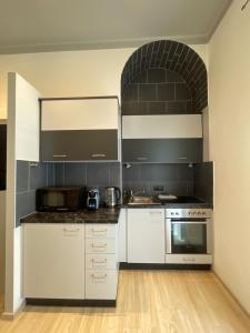 a kitchen with white cabinets and a stove at Stadtapartment WOHNEN48.AT in Klagenfurt