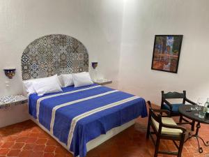 - une chambre avec un lit et une table avec des chaises dans l'établissement Casa Yollotzin, à Ajijic