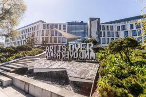 een parkbankje voor een gebouw bij Radisson Blu Hotel Sopot in Sopot