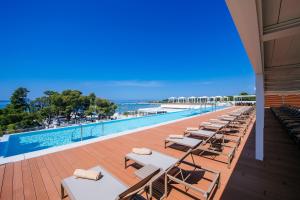 una fila de tumbonas junto a una piscina en Zaton Holiday Resort Mobile Homes, en Nin