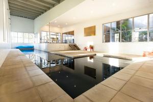 a large kitchen with a pool in the middle of a house at Springbank House in Jindy Andy