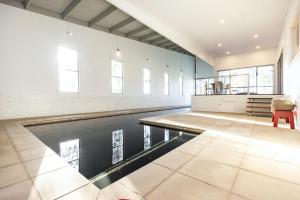 a swimming pool in a large room with a table and a chair at Springbank House in Jindy Andy