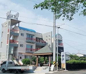 un camión estacionado frente a un edificio en Jeju Soroan Pension, en Seogwipo