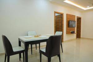 una sala da pranzo con tavolo e sedie di Padma Homes Stay- Luxury Service Apartment 1BHK & 2BHK & 3BHK a Tirupati