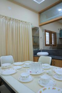 un tavolo con piatti e ciotole sopra di Padma Homes Stay- Luxury Service Apartment 1BHK & 2BHK & 3BHK a Tirupati