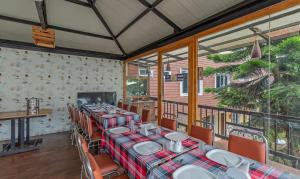 - une salle à manger avec des tables, des chaises et des fenêtres dans l'établissement Treebo Kodai Kings Park, 650 M From Kodai Lake, à Kodaikānāl