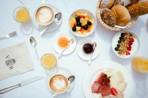 une table avec des tasses de café et des assiettes de nourriture dans l'établissement Villa Bavaria, à Merano