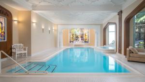 - une piscine au milieu d'un salon avec une grande piscine bleue dans l'établissement Villa Bavaria, à Merano