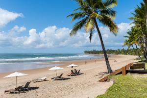 einen Strand mit Liegestühlen und Sonnenschirmen und dem Meer in der Unterkunft Pousada Encanto da Lua in Barra Grande