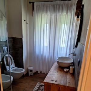 a bathroom with two sinks and a toilet and a shower at 4Seasons appartamenti in Sauze dʼOulx