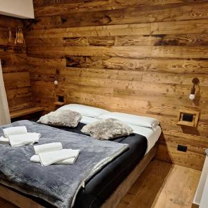 a bedroom with a bed in a wooden wall at 4Seasons appartamenti in Sauze dʼOulx