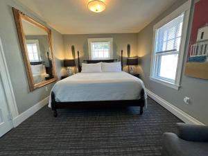 a bedroom with a bed and a mirror at Gifford House in Provincetown