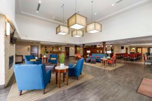 un hall d'un hôtel avec des chaises et des tables bleues dans l'établissement Comfort Suites Carlsbad, à Carlsbad