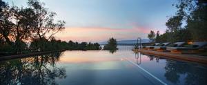 een zwembad met ligstoelen en een zonsondergang bij Maslina Resort in Stari Grad