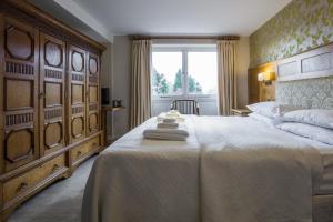 een slaapkamer met een groot bed en een raam bij Yewfield Vegetarian Guest house in Ambleside