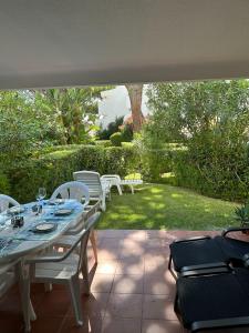 uma mesa e cadeiras num pátio com um jardim em Solar dos Pinheiros 105 em Vilamoura