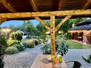 eine hölzerne Pergola mit einem Holztisch im Garten in der Unterkunft Gościniec Joanna in Rajgród