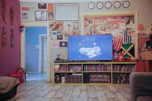 una sala de estar con TV en un estante de libros en Habitat Hostel, en Belgrado