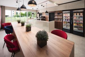 uma sala de jantar com uma grande mesa de madeira e cadeiras vermelhas em Johanniter Gästehaus em Münster