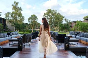 uma mulher de vestido branco a andar num passeio marítimo em Hua Hin Marriott Resort and Spa em Hua Hin