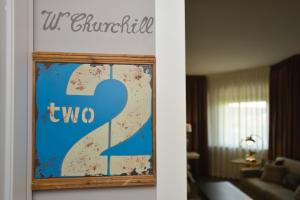 ein Schild an der Wand im Wohnzimmer in der Unterkunft Like Home Boutique Hotel in Azzano San Paolo