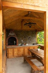 uma cozinha exterior com uma mesa e um forno de pedra em Sobe Jovan em Soko Banja