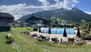 - une piscine avec des chaises et des parasols dans la cour dans l'établissement Hotel Senningerbräu, à Bramberg am Wildkogel