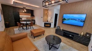 een woonkamer met een bank en een flatscreen-tv bij Relax House NS in Novi Sad