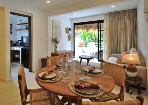 - une salle à manger avec une table et des chaises en bois dans l'établissement Amara Uluwatu, à Uluwatu